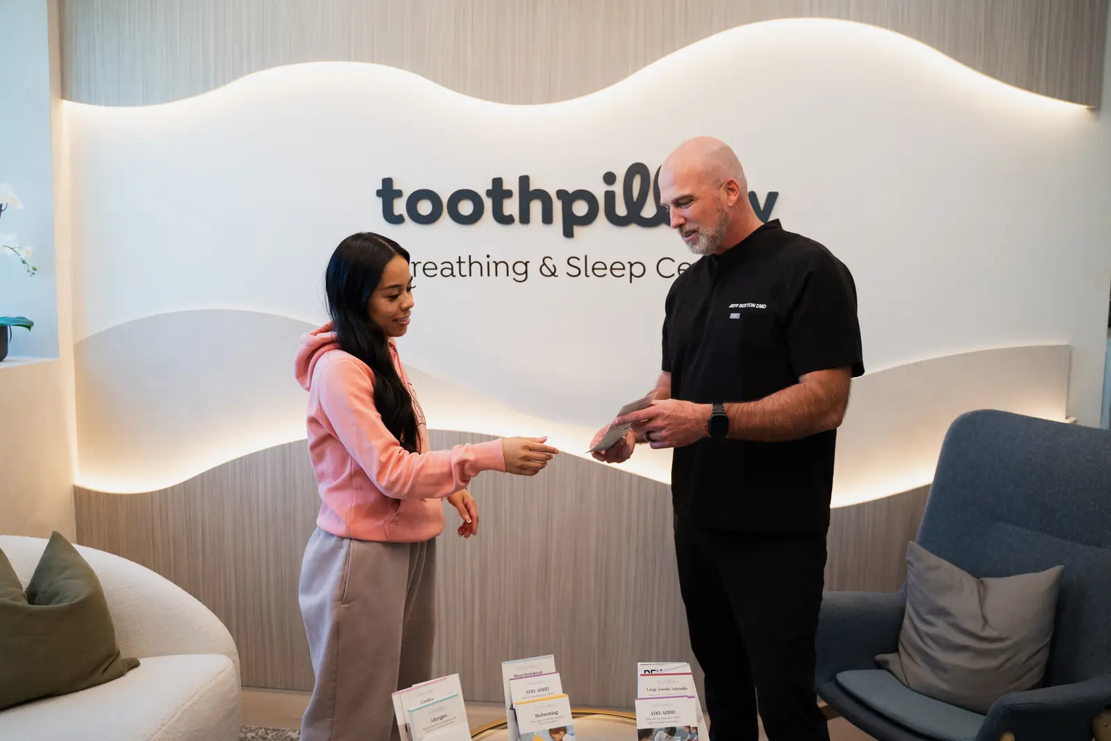 Dr. Jeff Buxton handing information to a patient at Toothpillow Breathing and Sleep Center in Draper, Utah