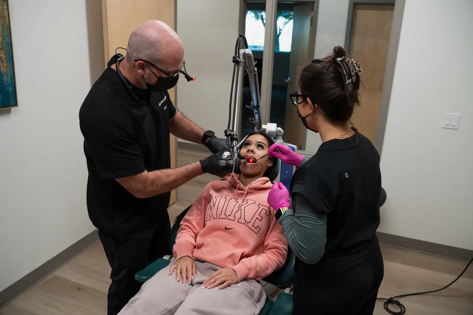 Dr. Jeff Buxton and an assistant performing laser treatment on a patient at Toothpillow Breathing & Sleep Center in Draper, Utah