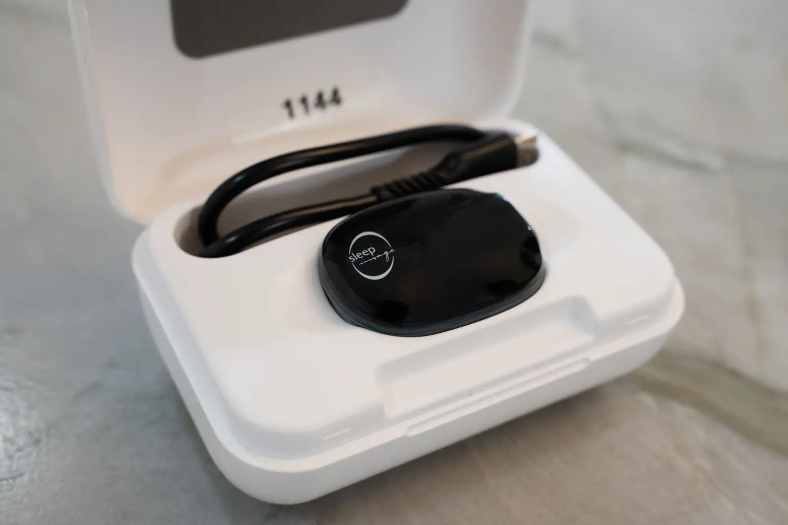 At-home sleep test ring in its charging case